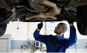 Man in blue coveralls fixing a vehicle