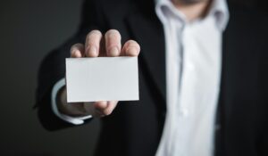 Businessman holding blank white business card.