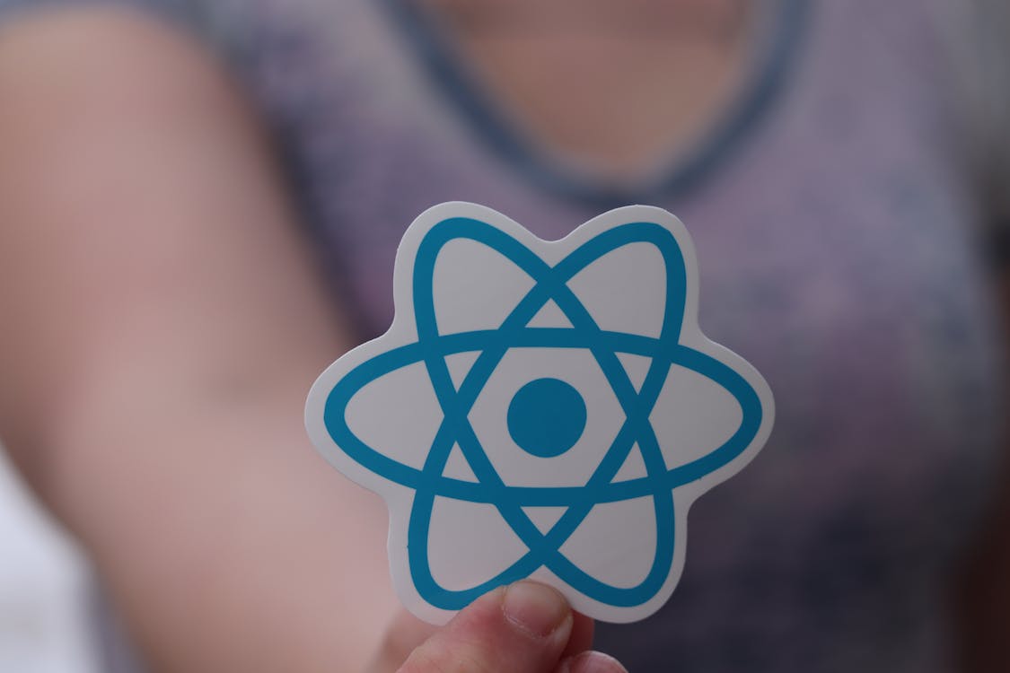React logo held in hand representing JavaScript development for startups