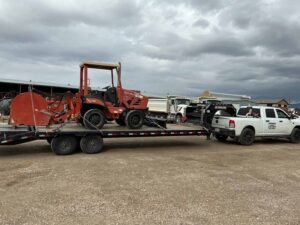 Hotshot truck hauling a compact utility machine on a gooseneck trailer