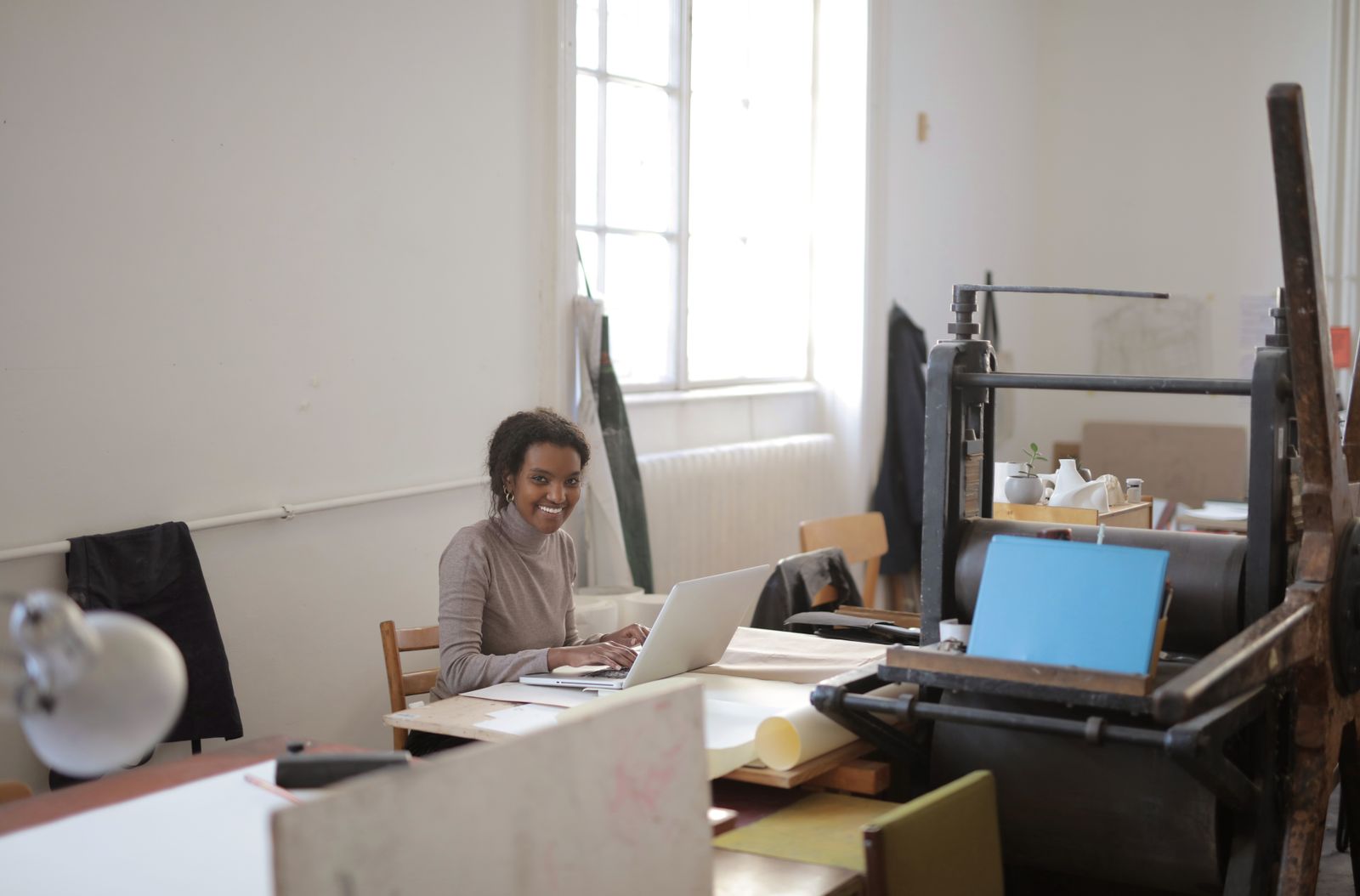 Small-business owner working at a laptop in a print workshop
